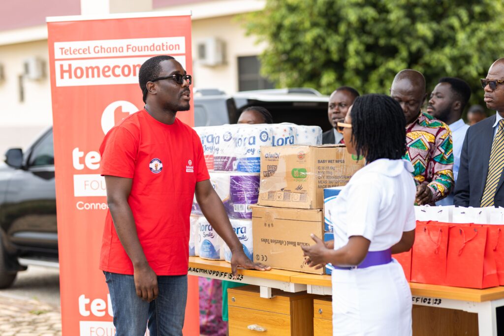 Community members participate in an outdoor charity event distributing essential supplies.